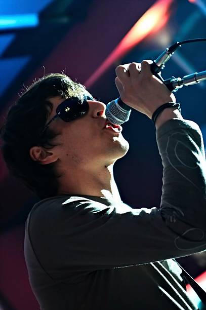 Man with sunglasses on singing in a dark venue stock photo