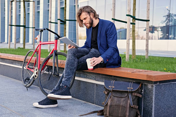 istock A man holds tablet PC with red single speed bicycle on background. 967526748