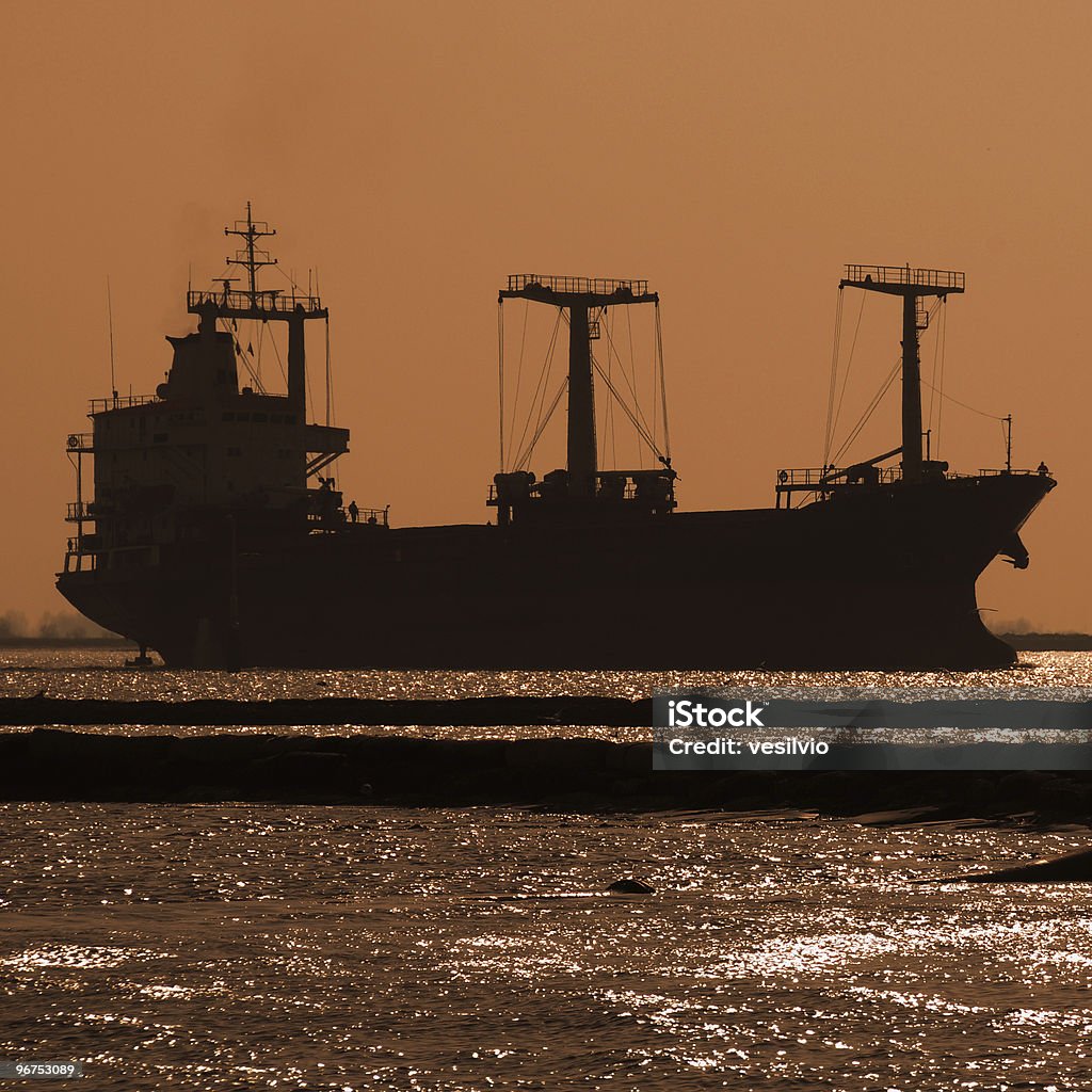 Merchant navy Silhouette of an industrial ship at sunset. Back Lit Stock Photo