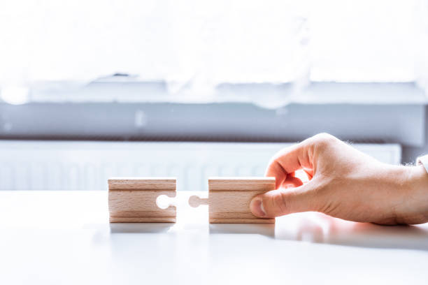 istock Hand holding a wooden jigsaw puzzle with blank space. 967535524