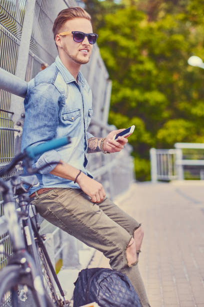 istock Cyclist using a smartphone on a steel bridge. 967544950