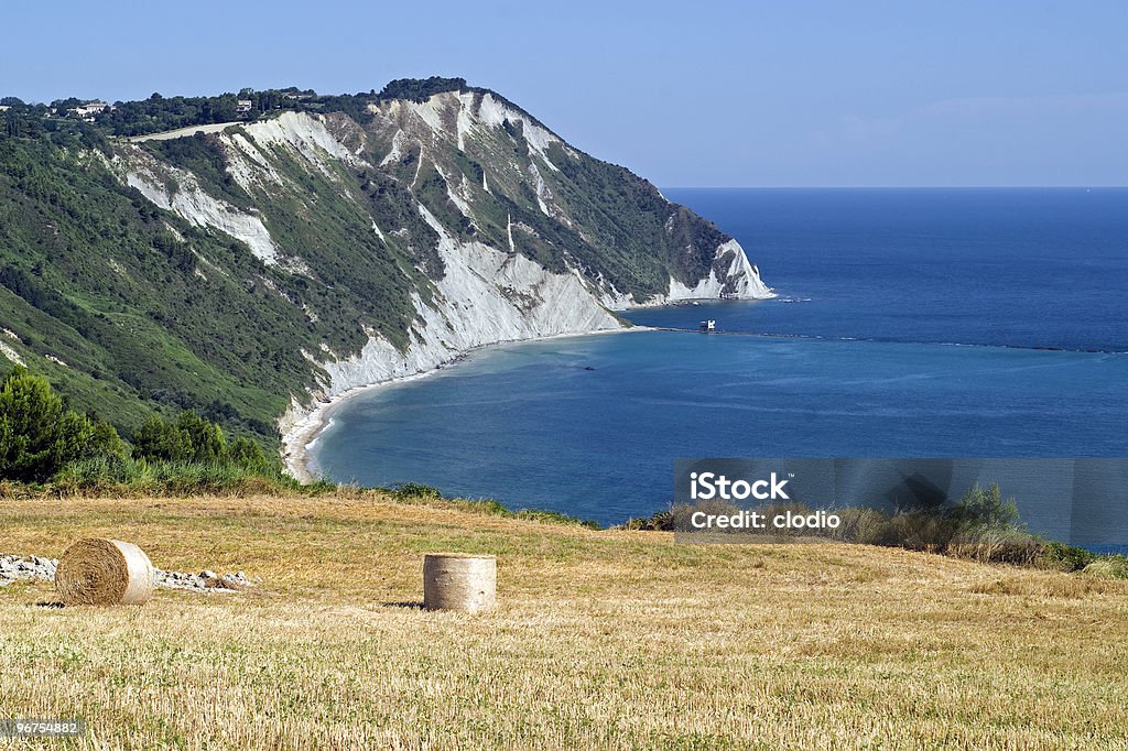 Conero (Ancona), the coast and cultivated field Conero (Ancona, Marche, Italy) - Cultivated coast and beach: bales on a field in front of the blue water of the Adriatico sea Coastline Stock Photo