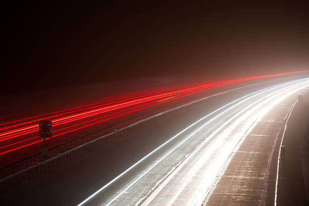 Light trails on a foggy motorway  m40 sniper rifle stock pictures, royalty-free photos & images