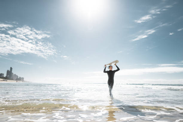 surfer walking in surfers paradise beach in australia