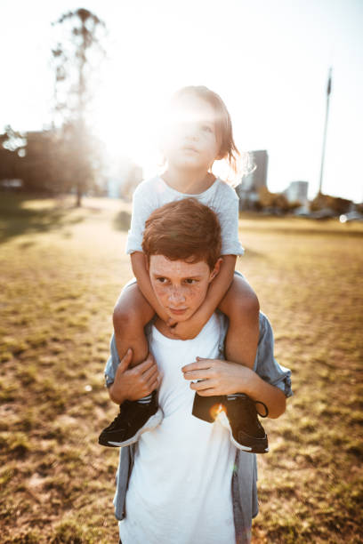 istock two lovely kids piggyback at the park 967611606