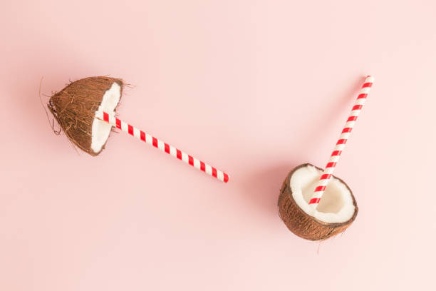 istock Flat lay of coconut with drinking straws against pastel pink background. 967646476
