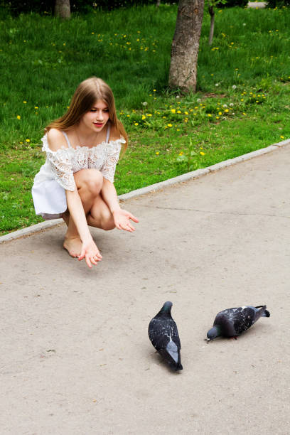 istock Barefoot girl feeding pigeons. 967651296