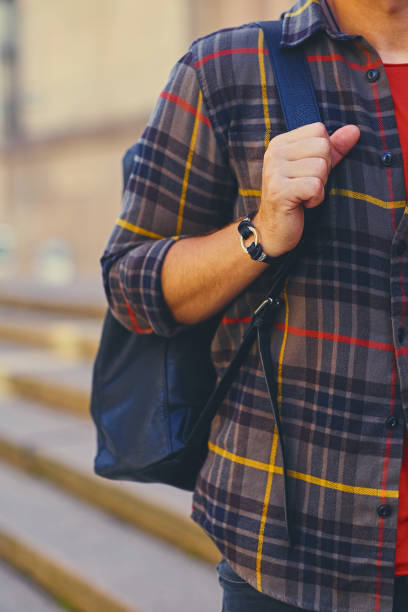 istock A man in a fleece shirt holds a backpack on a shoulder. 967655106