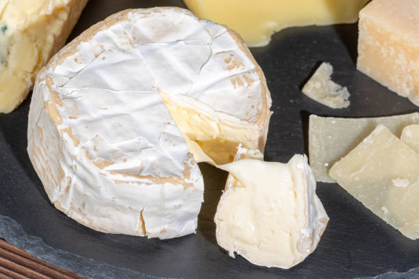 istock portion of fresh white cheese with mold and various types of cheese on black slate texture, close up 967660616