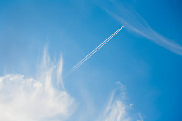 un aereo a reazione traccia una scia di inversione nel cielo. - vapor trail cirrus sky cloudscape foto e immagini stock