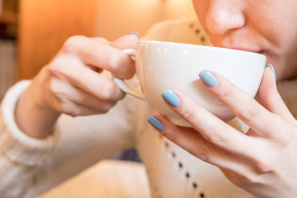istock Woman with blue nails drinks  cup of hot coffee. Toned 967664712