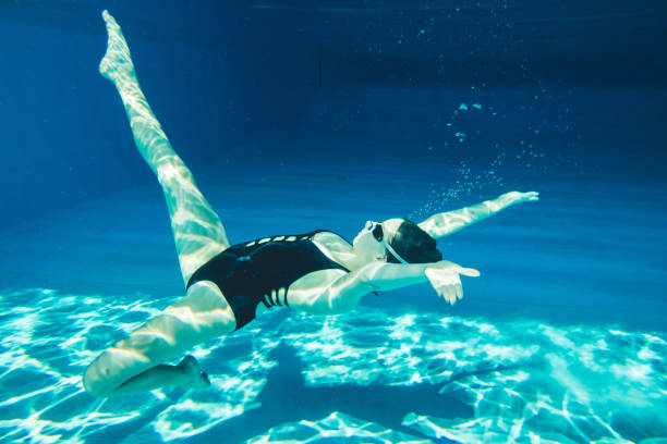 istock Young woman in pool and synchronized swimming. 967672452