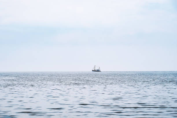 distant shrimp boat at the horizon, north sea in Germany
