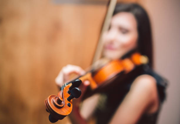 joven y bella mujer artista tocar el violín en el escenario. - musical theater child violin musical instrument fotografías e imágenes de stock