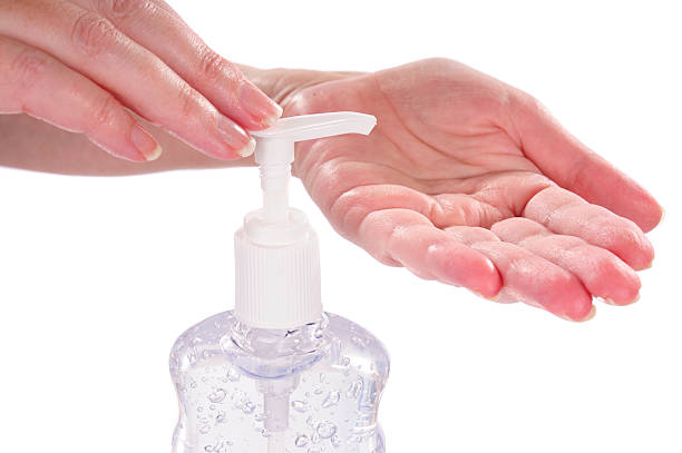 Woman sanitizing her hands with germ protection stock photo