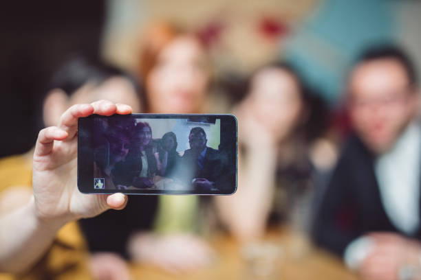istock Four best friends sitting in a cafe and and make selfie. 967705432