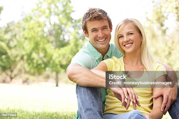 Photo libre de droit de Portrait De Jeune Couple Assis Dans Le Parc banque d'images et plus d'images libres de droit de Adulte - Adulte, Adulte d'âge mûr, Affectueux