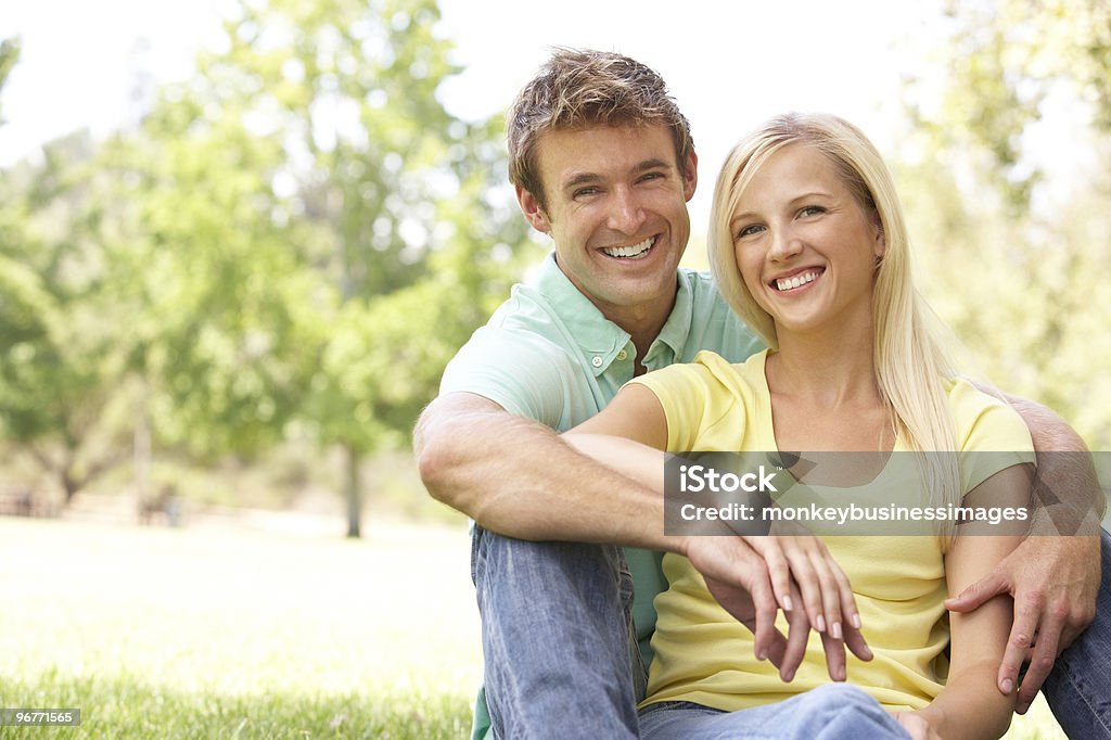 Retrato de casal jovem sentado no parque - Foto de stock de 20 Anos royalty-free