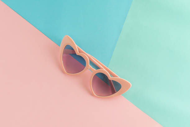 istock Heart shape sunglasses on pastel colors background, Summer concept 967725484