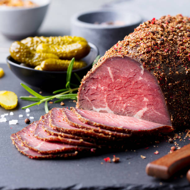Roasted beef, pastrami on slate cutting board. Close up. Roasted beef, pastrami on slate cutting board. Close up. pastrami stock pictures, royalty-free photos & images