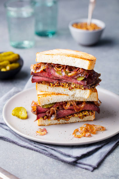istock Roast beef sandwich on a plate with pickles. 967732034