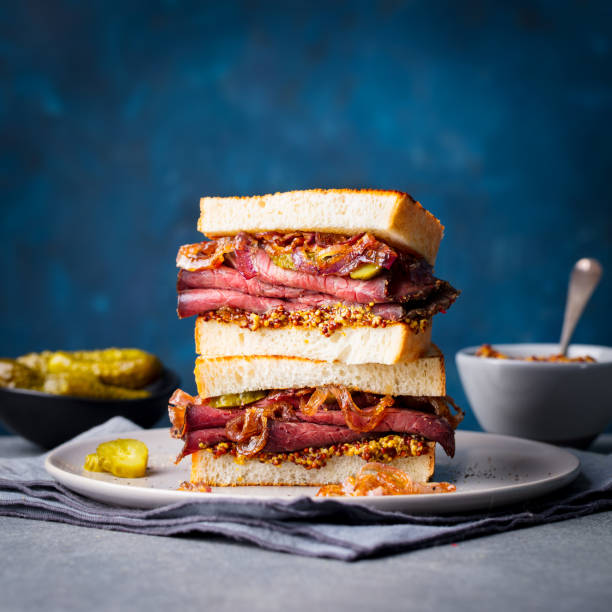 istock Roast beef sandwich on a plate with pickles. Copy space. 967733090