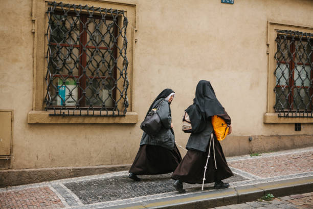 Prague, September 18, 2017: Two nuns go in a blurred motion along the street of the city and communicate Prague, September 18, 2017: Two nuns go in a blurred motion along the street of the city and communicate. nun catholicism sister praying stock pictures, royalty-free photos & images