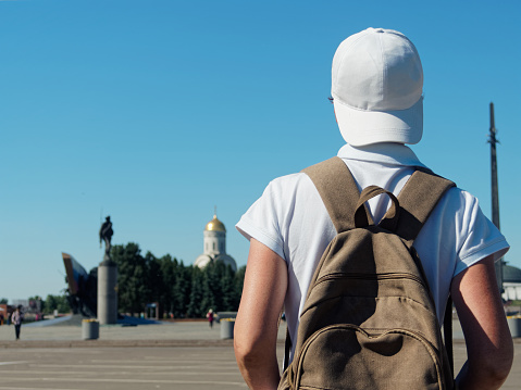 Tourist wearing white cap is exploring Victory park in Moscow, Russia. Uncertain gender. Rear view