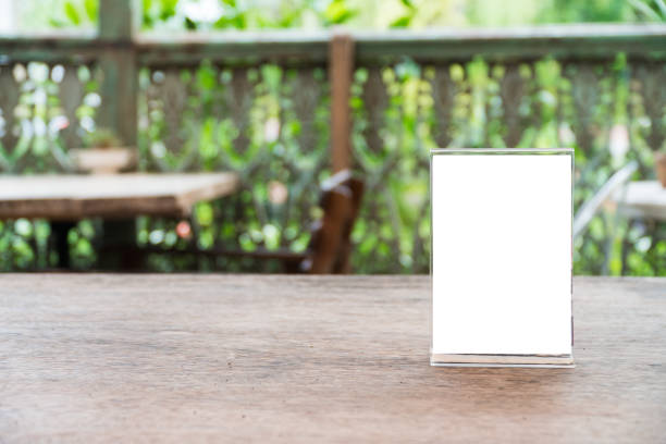 istock mock up menu object in cafe and restaurant,blank screen for booklet with white sheets of paper on wooden table on cafeteria,copy space for text or graphics object 967765704