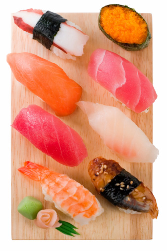 A selection of freshly prepared nigiri sushi with fatty tuna, salmon, tobiko, eel, shrimp, yellowtail, octopus and garnish with traditional nori and wasabi.  Shallow dof.  Isolated