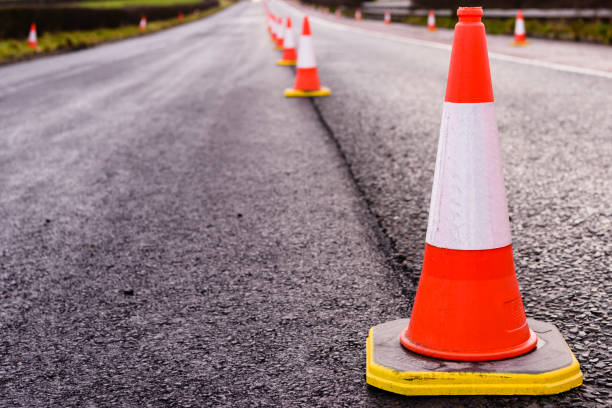 Row of traffic cones along the middle of a road being resurfaced. Row of traffic cones along the middle of a road being resurfaced. road construction stock pictures, royalty-free photos & images