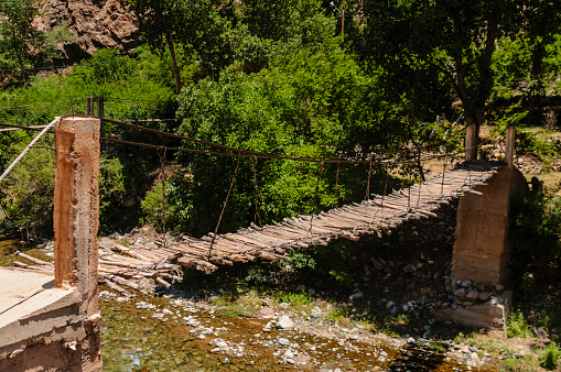 Rickety wooden rope bridge over the River Ourika high up in the Atlas Mountains, Morocco