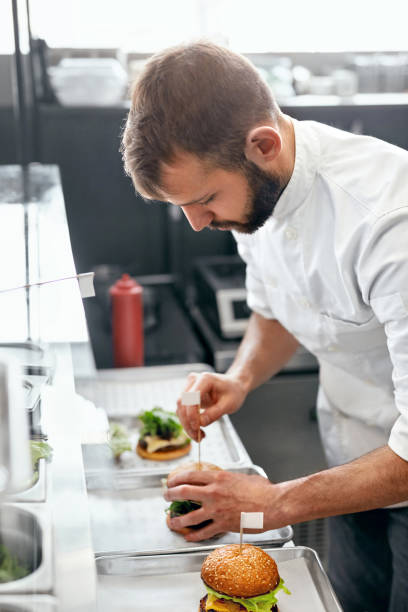 istock Chef Cooking Burgers in Kitchen 967780434