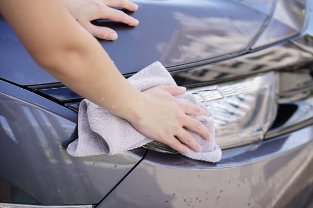 istock women hand dry wiping car surface with microfiber cloth after washing. 967784316