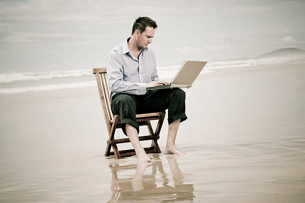 istock business man on the beach with laptop 96778773