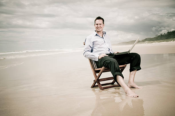 istock business man on the beach with laptop 96778775