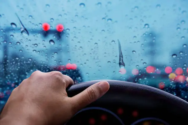 Drive in Rainy Day. Bad Weather on the Road with Blurred Lights and Traffic Jam in City. Front View Snap from Driver Position