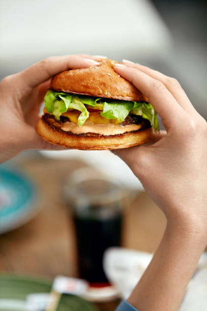 istock Eating Burger. Woman Holding Hamburger In Hands 967788792