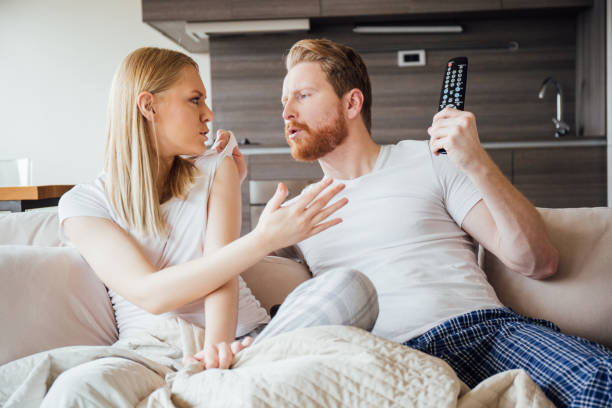 Man grabbing woman by the sleeve while arguing Couple having fight in the living room clingy girlfriend stock pictures, royalty-free photos & images