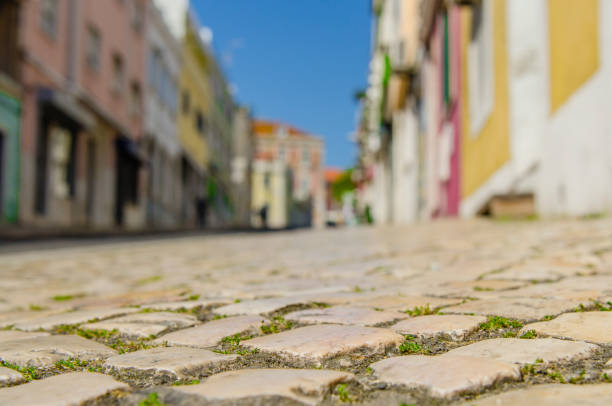 Ancient cobbled stone road detail in Lisbon against the background of old houses
