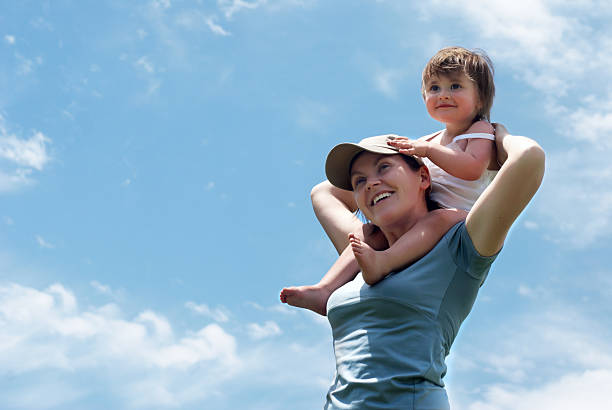 The mother with small daughter against sky stock photo