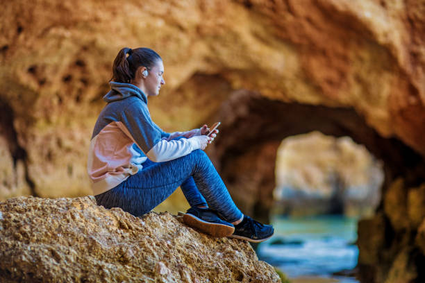 istock Young brunette female enjoying her independence and wanderlust spirit whilst using a handheld mobile device 967827424