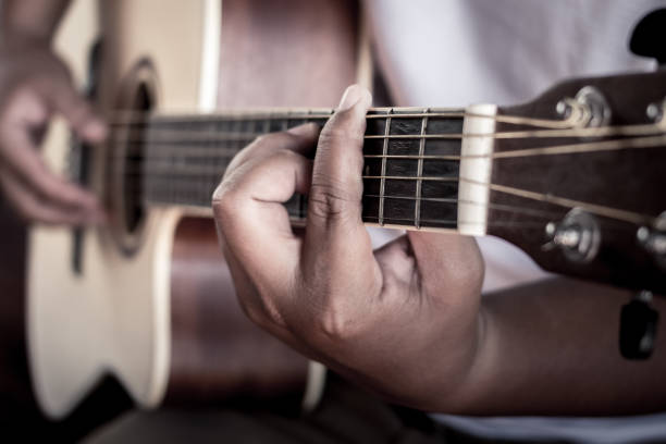 istock Close up of man hand playing guitar. 967836604