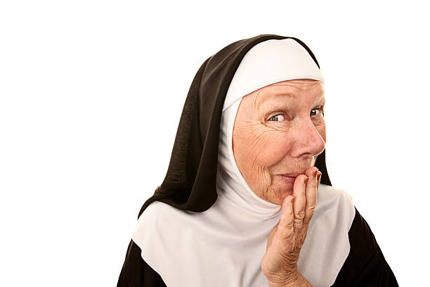 Older nun holding in a laugh with her hand stock photo