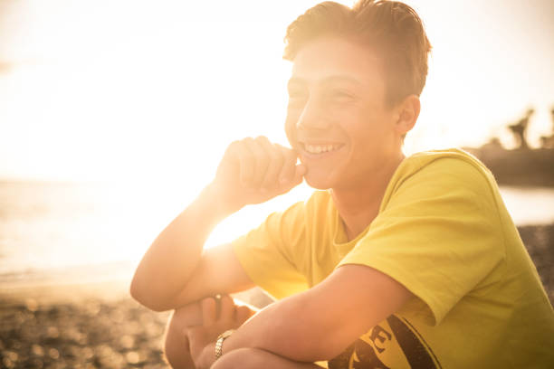 金髪で美しいティーンエイ ジャー、日光とテネリフェ カナリア諸島で背景の夕日 14 歳。若いモデルは自由やビーチをお楽しみください。 - 13 14 years 写真 ストックフォトと画像