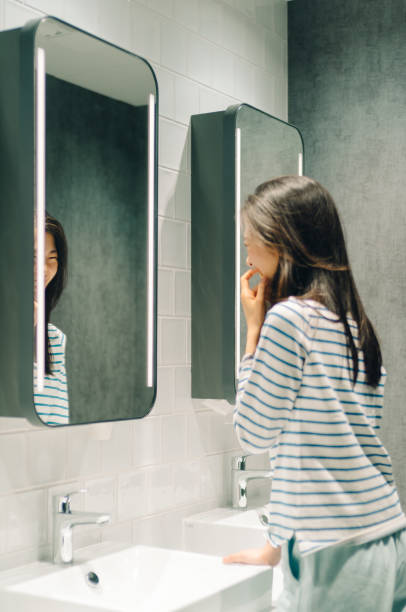 istock Young women standing in front of mirror. 967889910