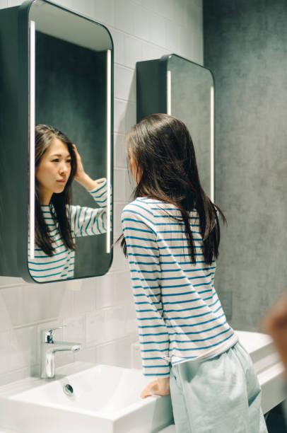 istock Young women standing in front of mirror. 967889928