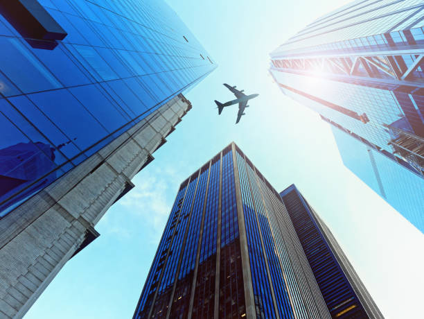 istock Looking Up glass skyscrapers silhouette airplane flying 967902882