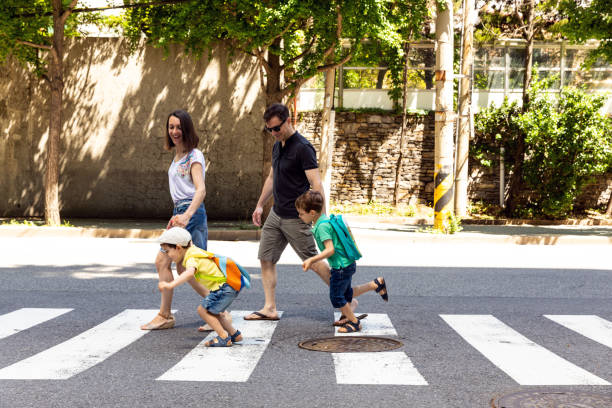 familia cruzando la calle... que se divierten - familia de cruzar la calle fotografías e imágenes de stock