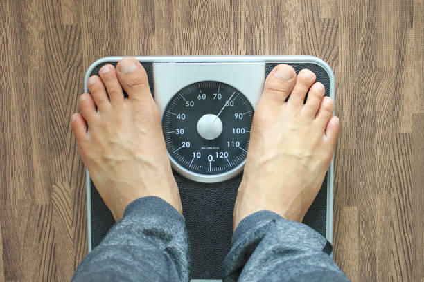 istock Male on the weight scale for check weight, Diet concept 967910200
